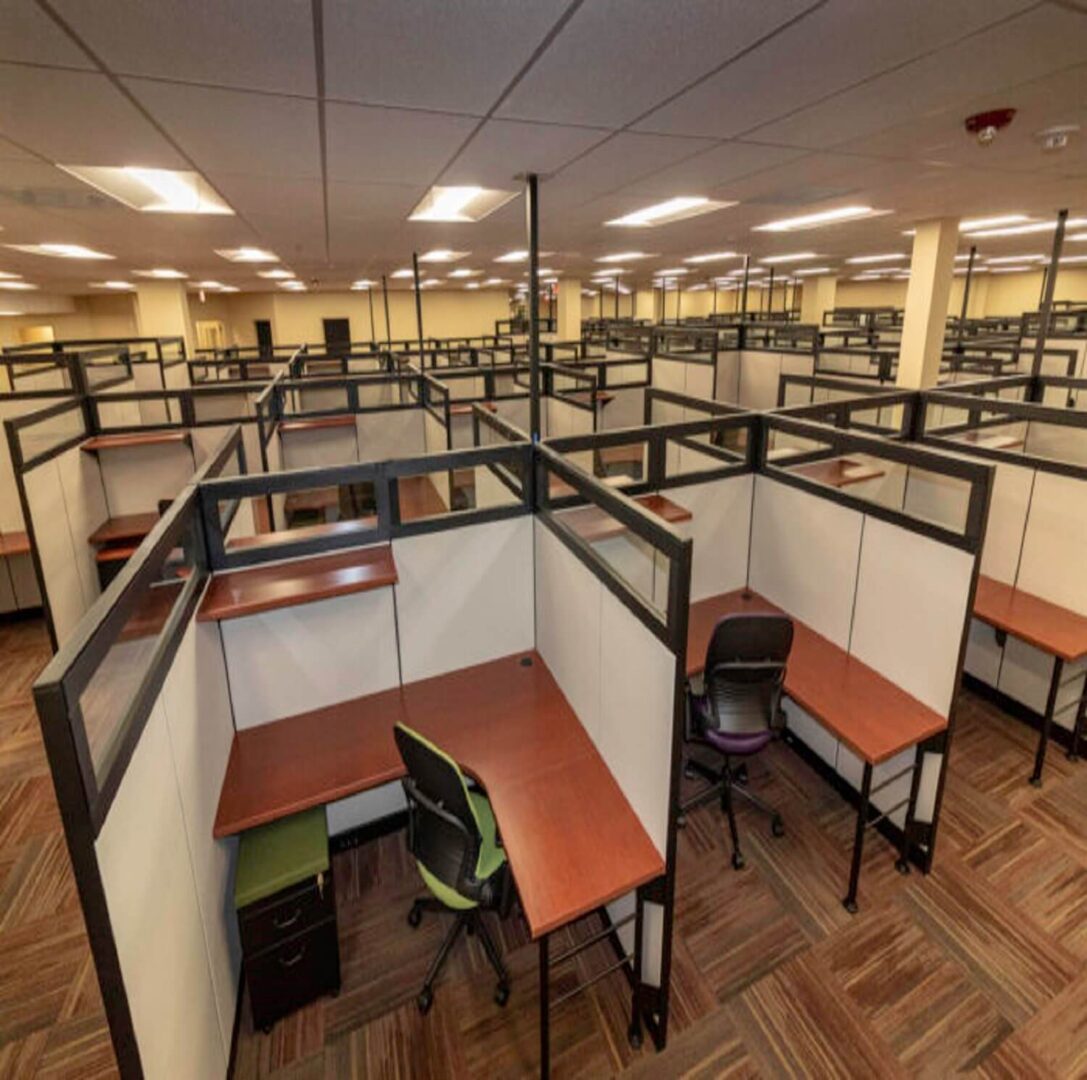 Empty office cubicles with chairs and desks.